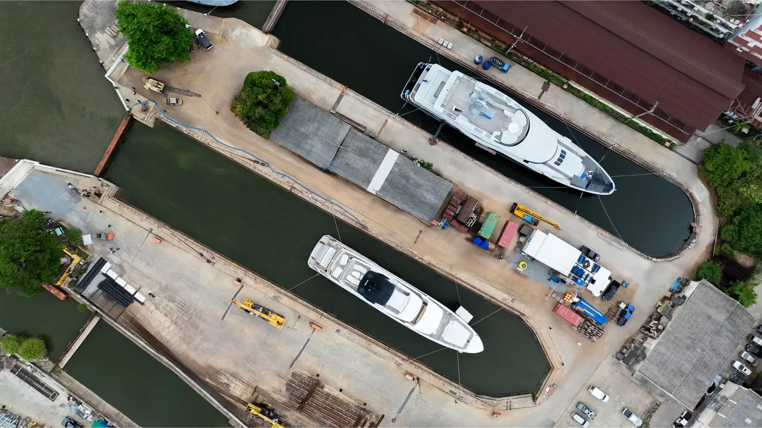 Bangkok superyacht refit Shipyard from above, showing 2 dry docks with a white superyacht resting in each