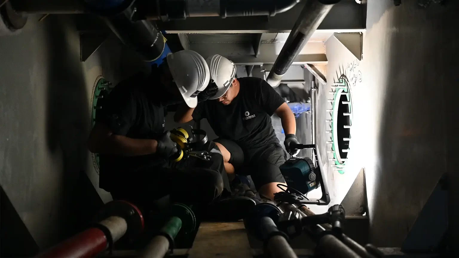 two marine mechanical engineers are seen working on the inside of a large marine vessel