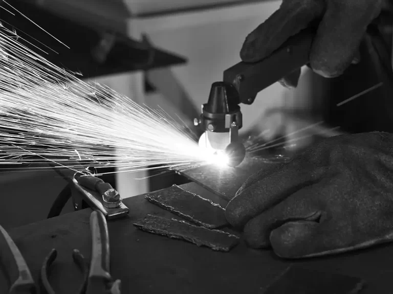 sparks can be seen emanating from the drinding of a piece of steel in a marine mechanical engineering workshop