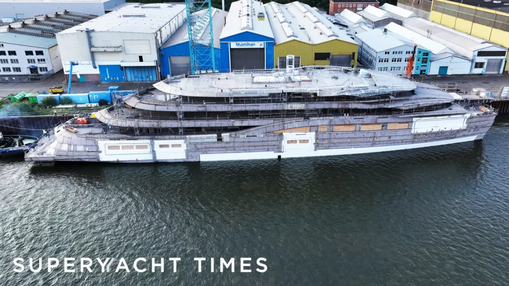 Aerial view of Lürssen’s 134m superyacht Deep Blue under construction at the Muehlhan facility in Bremen, showing the unfinished hull and multi-tiered deck structure during the outfitting phase.