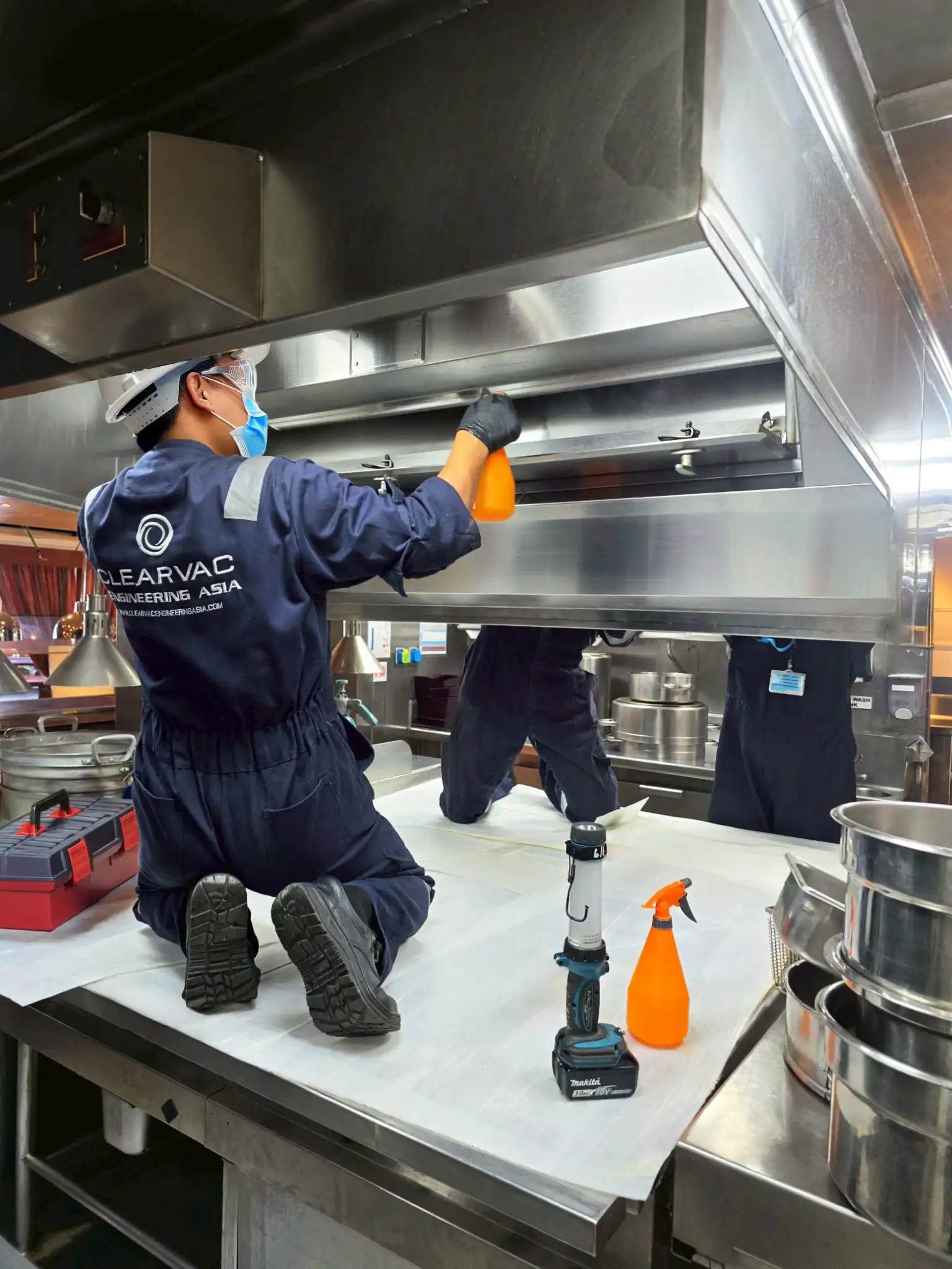 Clearvac engineer cleaning yacht galley extraction system to remove grease and fire hazards, ensuring marine fire safety compliance.
